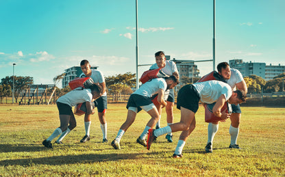 Group of rugby players in action on a field with buildings in the background